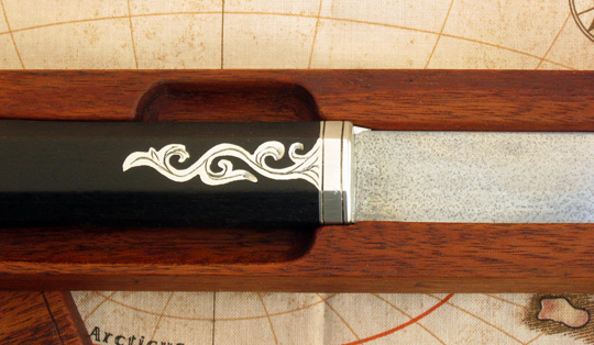 Hand engraved silver alloy bolster with integral side plates.