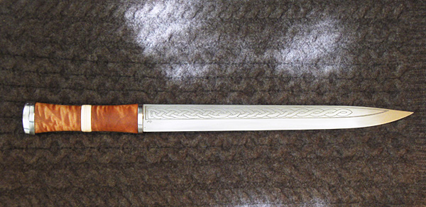 Hand forged 8670M blade with etched pattern, Steel hilt fittings, and quilted maple grip with bone spacer.